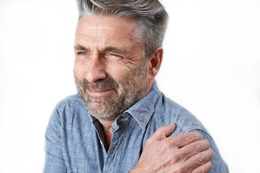 man in pain with hand on shoulder