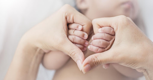 mother holding baby's hands